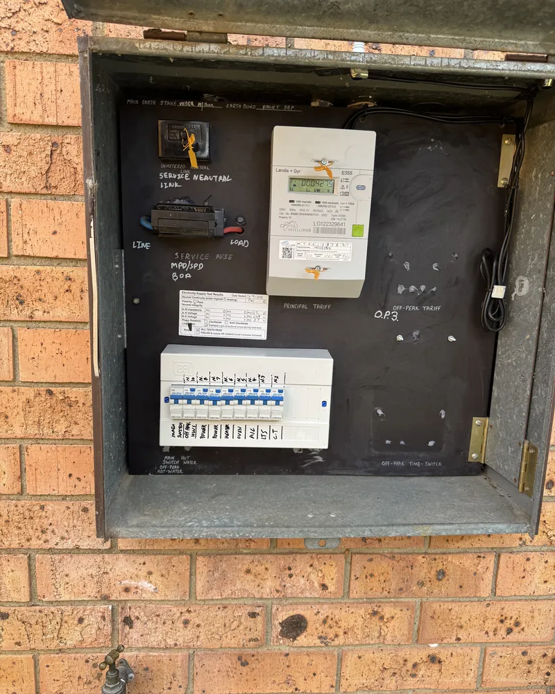 Meter box with replaced main switch and metering equipment on a brick wall